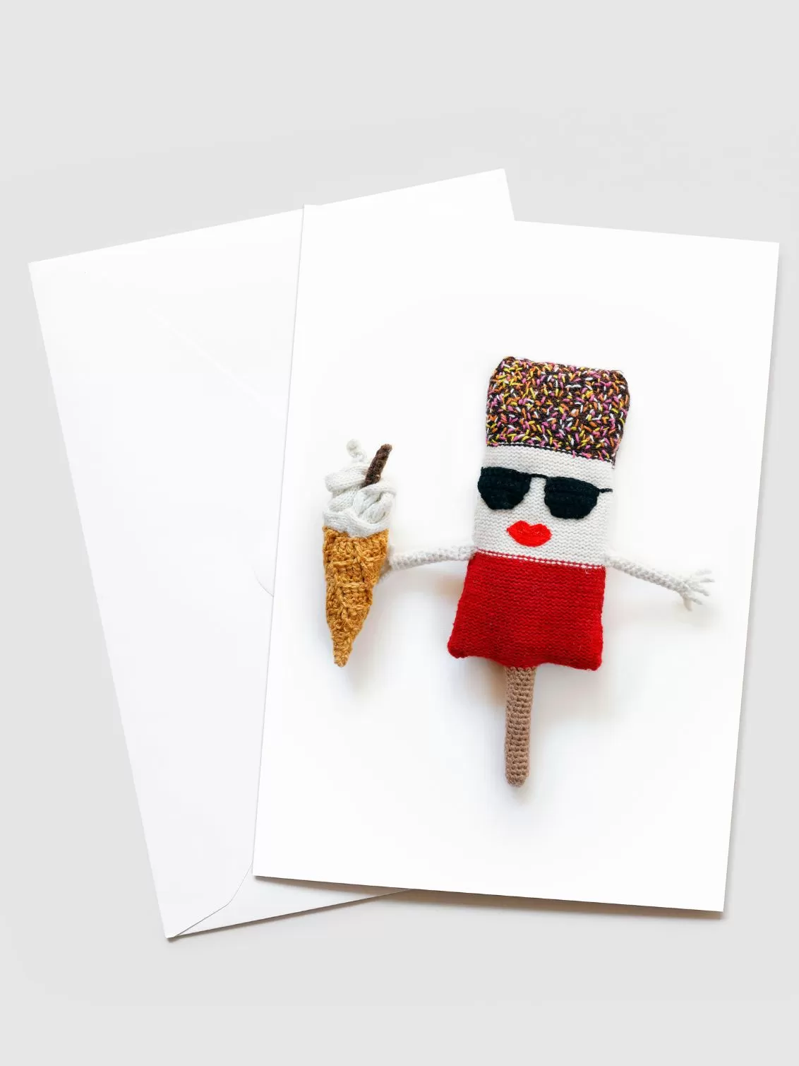 Kate Jenkins 'Ab Fab' Blank Greetings Card seen with a white envelope behind. On the front of the card is a crotched Ab Fab with pink lips, wearing sunglasses and holding a 99 Flake.
