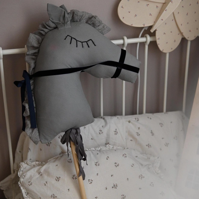 Handmade Cotton Hobby Horse Nursery Decoration, a cotton hobby horse sitting in a child's bedroom surrounded by other bedroom accessories. 