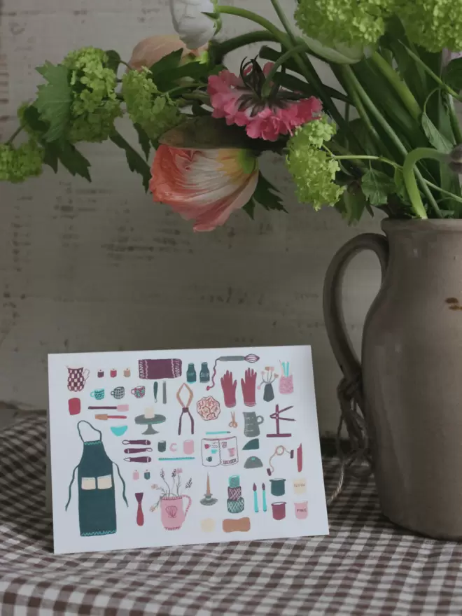 pottery greetings card next to vase of fresh flowers. 