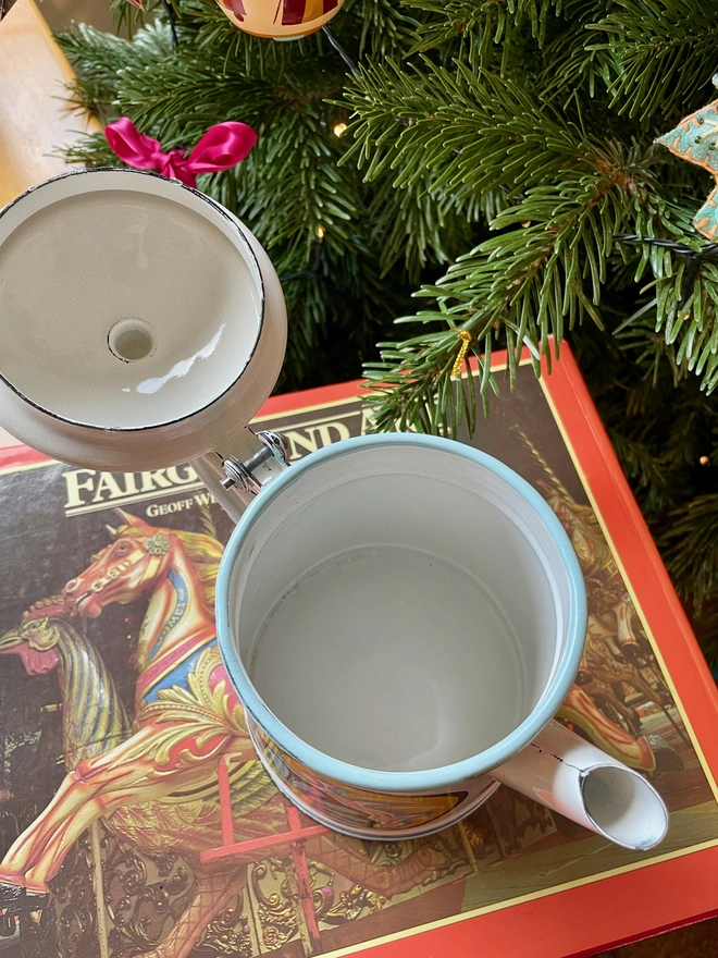 White enamel coffee pot hand painted with a fairground design in blue, pink and yellow