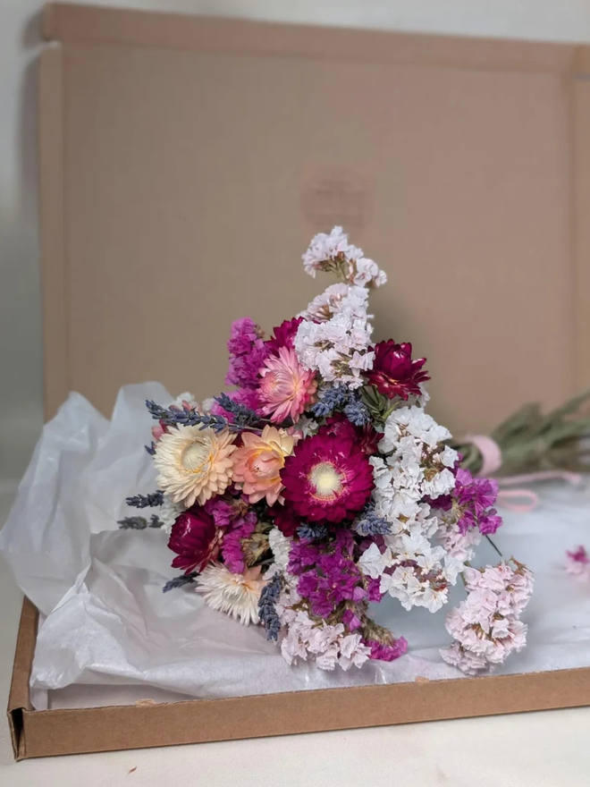 dried flower kit. pink, white and purple dried flower kit assembled into bouquet in packaging box.