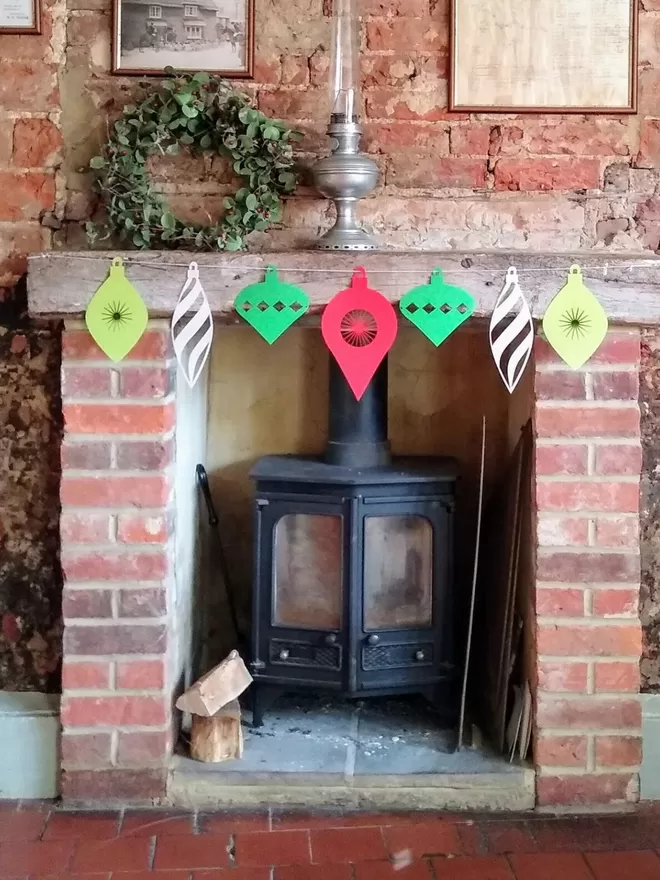 Christmas Ornament Paper Garland displayed on traditional mantelpiece with wood burning stove