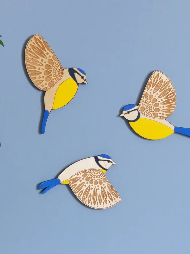Folk Art Wooden Blue Tits (Set Of 3), wooden blue tits hung up on a wall, flying. 
