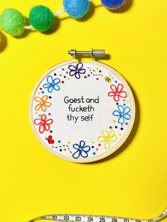 Hand embroidery hoop art reads Goest and fucketh thy self with a flower border