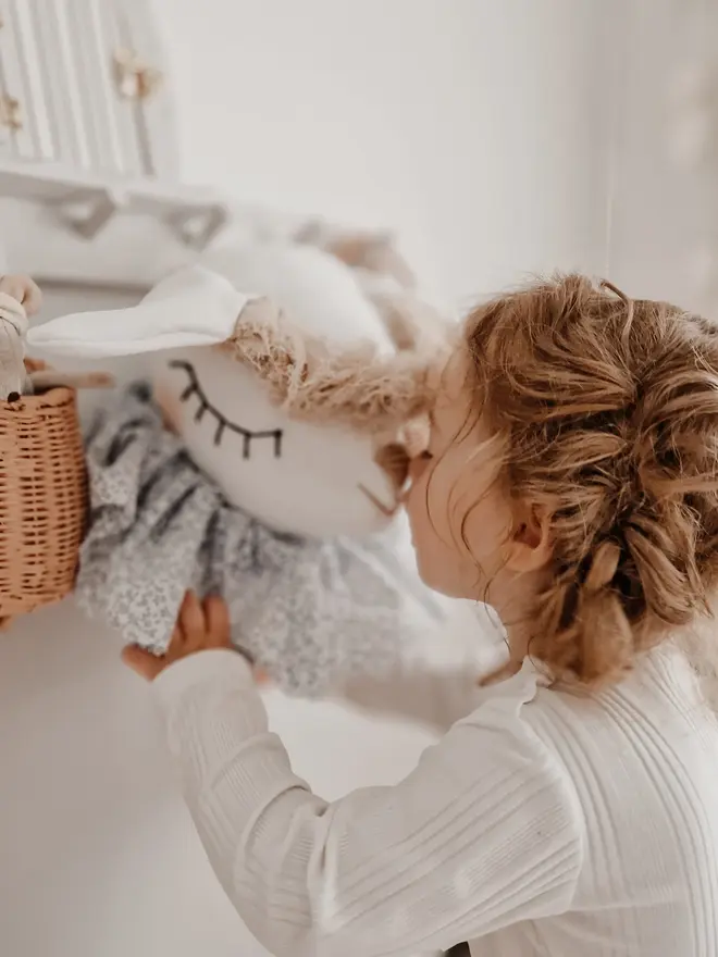 Sheep Head Wall Mount, a hanging sheep head decoration sitting against a plain wall in child's bedroom. 