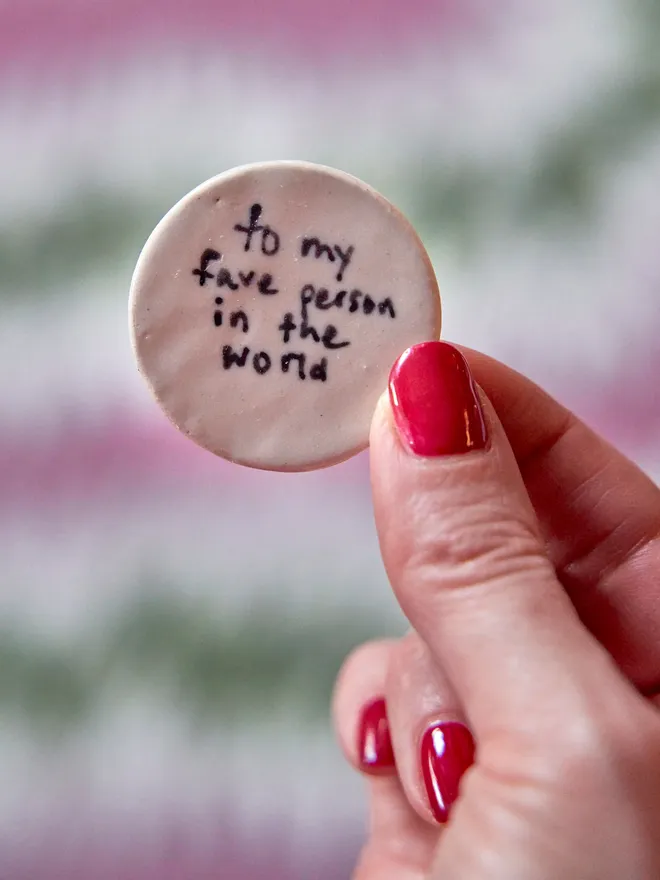 Small ceramic love token. A small ceramic love token which says to my favourite person in the world held up by someone.