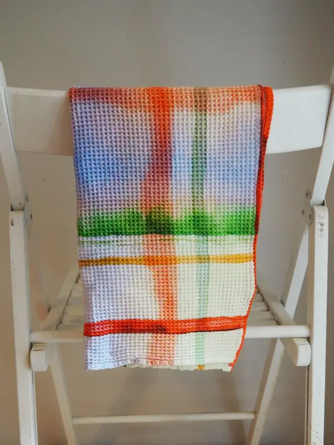 Check Waffle Tea towel, draped on a white chair. 