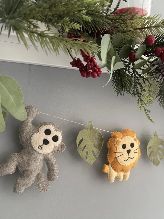 Nursery Safari Garland, a safari themed garland hanging in a child's bedroom against a grey backdrop. 