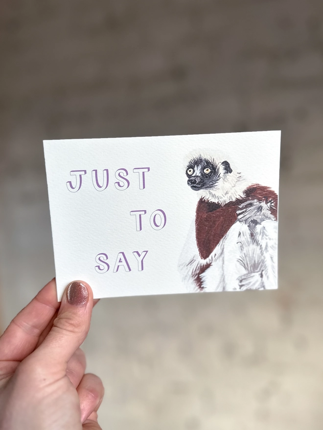  a greetings card featuring an illustration of a Coquerel’s Sifaka with the text “just to say”