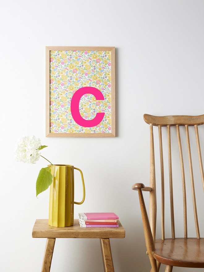 Personalised framed neon pink initial on Liberty Betsy yellow fabric