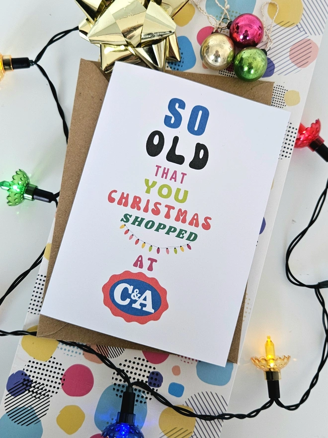 A photograph of the front of a humorous A6 greeting card illustrated using brightly coloured text and the retro shop logo. The text says so old you Christmas shopped at C&A