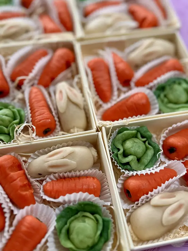 Marzi The Easter Bunny Marzipan, boxes of Marzi the Easter bunny marzipans grouped next to each other. In the boxes is the rabbit, carrots and kale. 