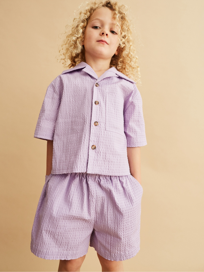 lilac seersucker shirt and short set perfect for holiday or wedding outfit for children. made by small kidswear brand studio koter in the uk using organic cotton. sustainable kidswear is their mission.