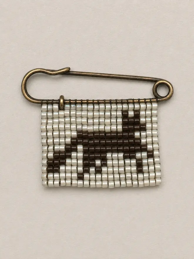 tiled beaded fox pin. a beaded pin badge with a brown fox on a pearl background.
