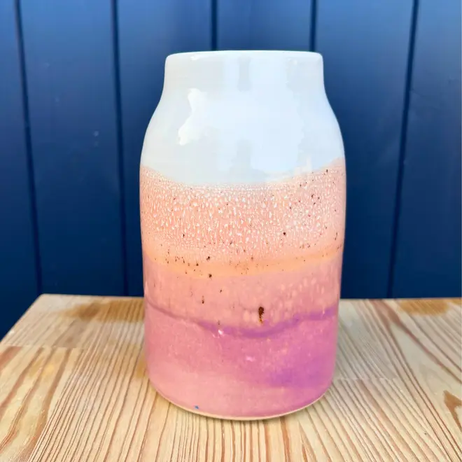 Ice Cream Sundae Large Vase, a colourful vase sitting on a wooden surface against a navy blue backdrop.