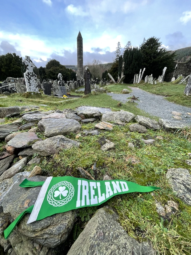 felt pennant flag rich pea green with white text saying IRELAND and a shamrock in a celtic patterned border