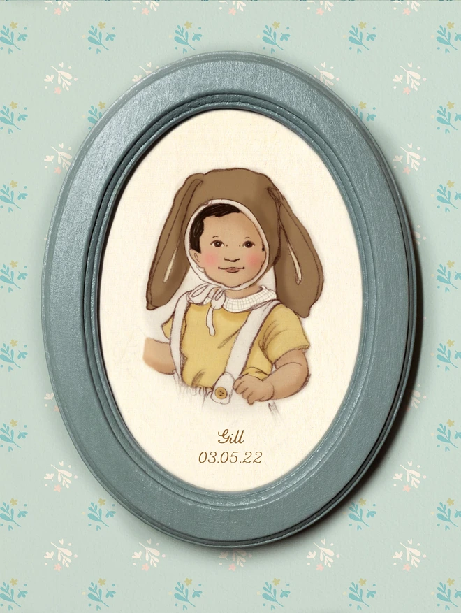 a photograph of a personalised portrait of an Indian asian boy wearing a bunny eater bonnet framed in a duck egg blue handmade wooden oval frame hand drawn in pencil giclee print pastel coloured easter colours