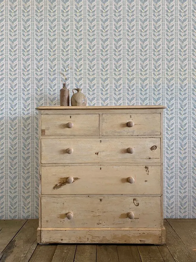 leaf stripe illustrated wallpaper. a blue leaf patterned wallpaper on a wall.