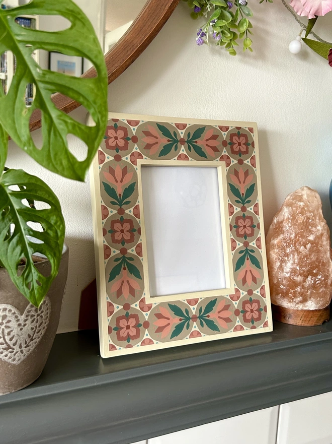 Folk art inspired hand painted decorated flower patterned photo frame painted in pinks, green, cream and light brown