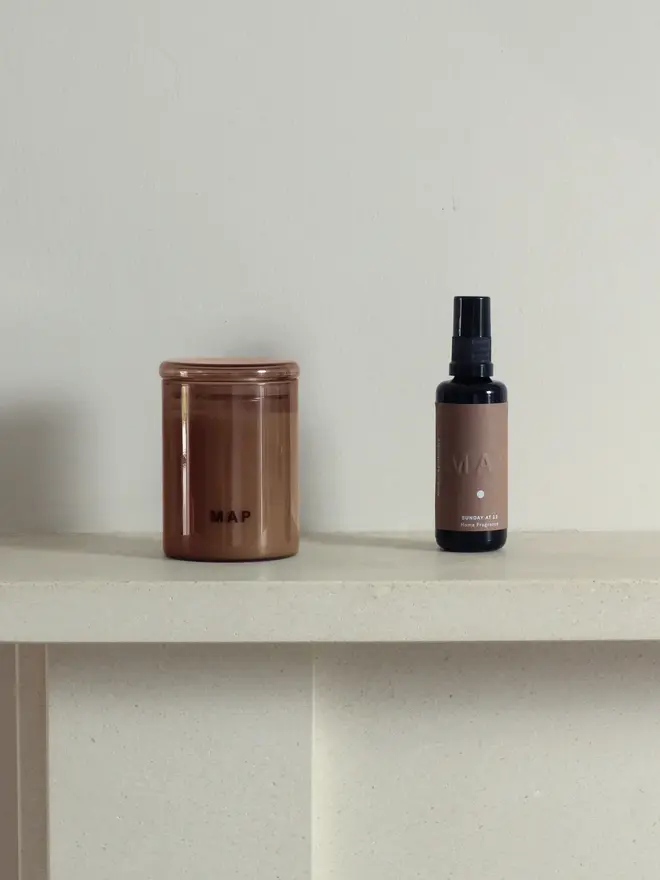 calm aromatherapy candle and home fragrance spray set. candle and spray bottle photographed on shelf.