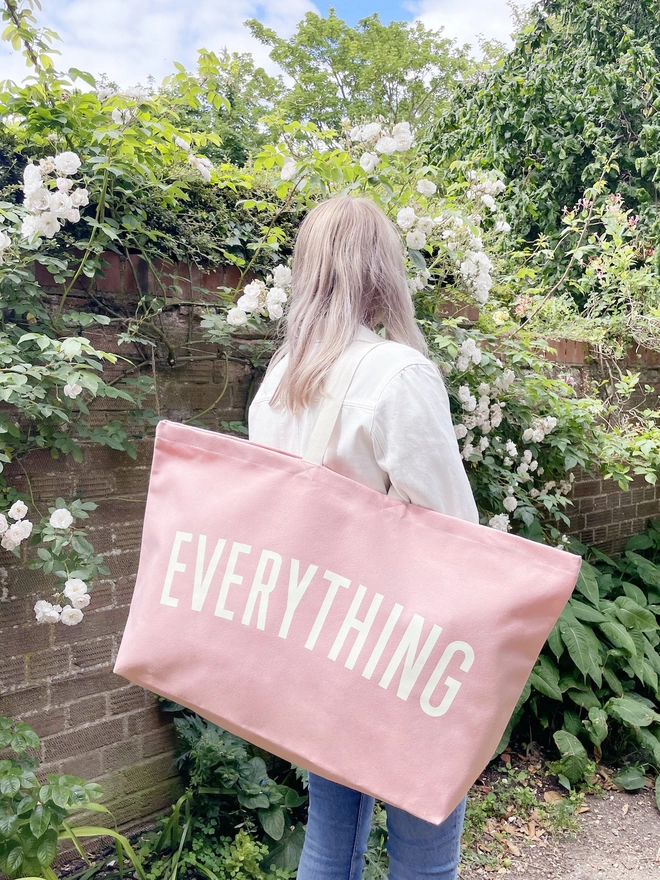 Model holding the Everything oversized canvas tote bag in Pink