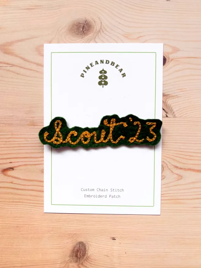 Personalised Chain Stitch name patch in green and mustard on a white presentation card