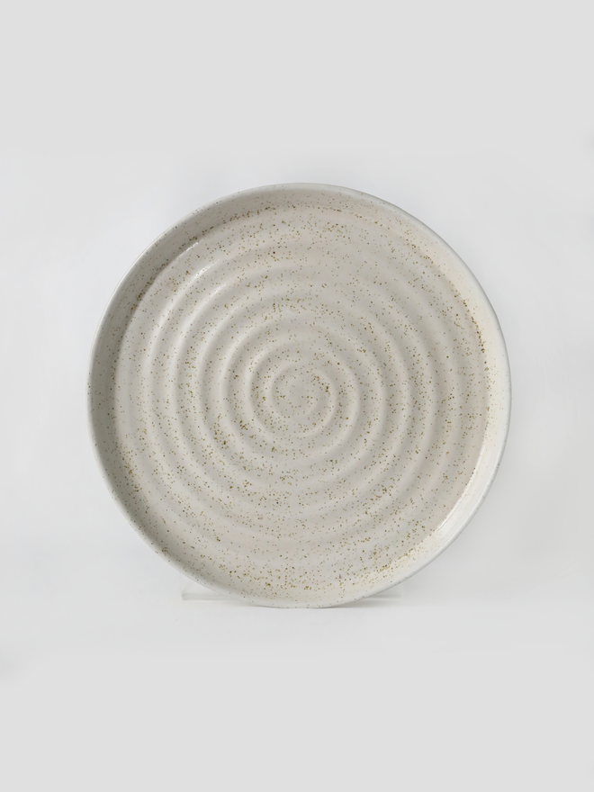 A handmade ceramic side plate in pepper white glaze, photographed from the front against a plain white background, showing a natural concentric swirl texture from the wheel-throwing process
