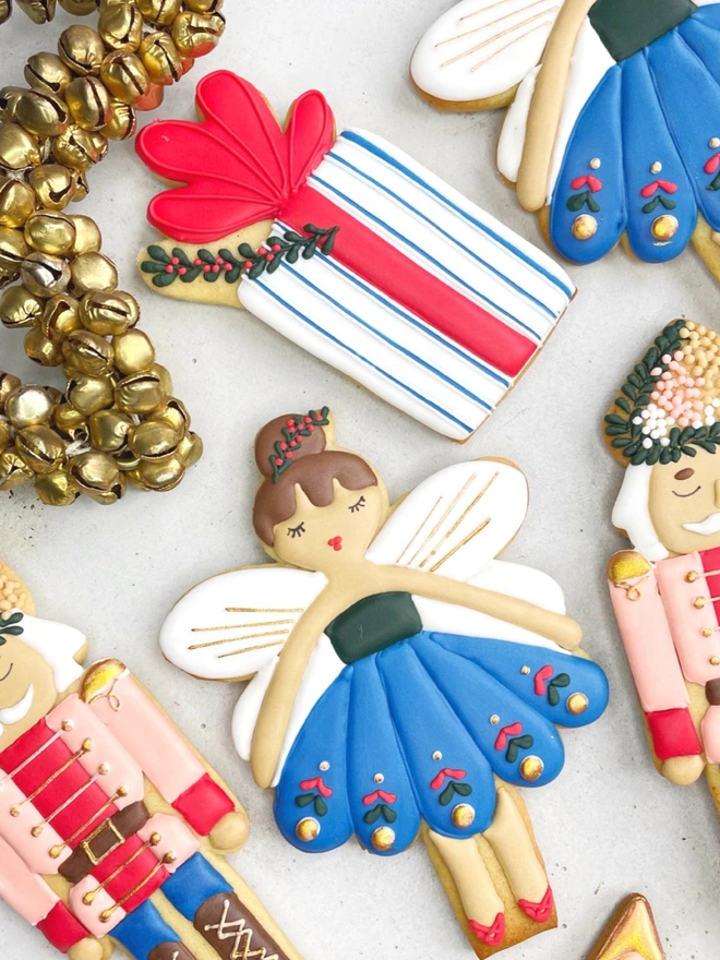 Hand-iced Christmas biscuits featuring a Nutcracker and a present in a festive gift box, available in Vanilla or Gingerbread flavour