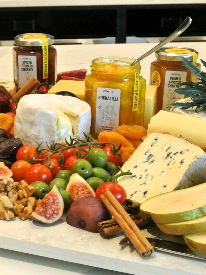 puckalilli piccalilli. a charcuterie board featuring jars of artisan pickles.