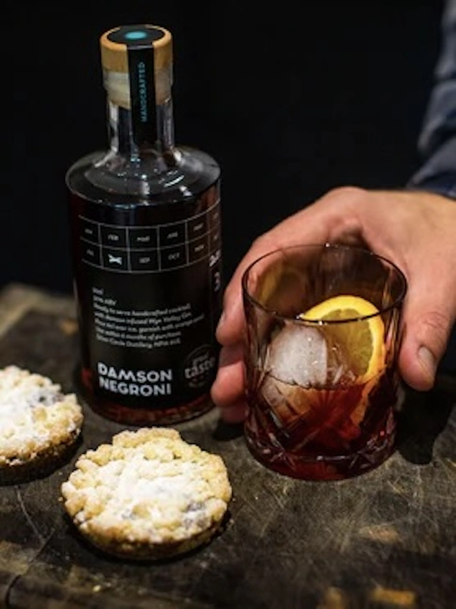 The Holiday Essentials Bundle (Pack Of 7), glass of alcohol next to a bottle of spirit. 