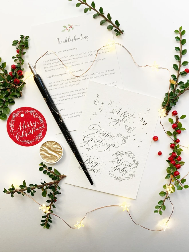 christmas modern calligraphy kit. black calligraphy on white writing paper.