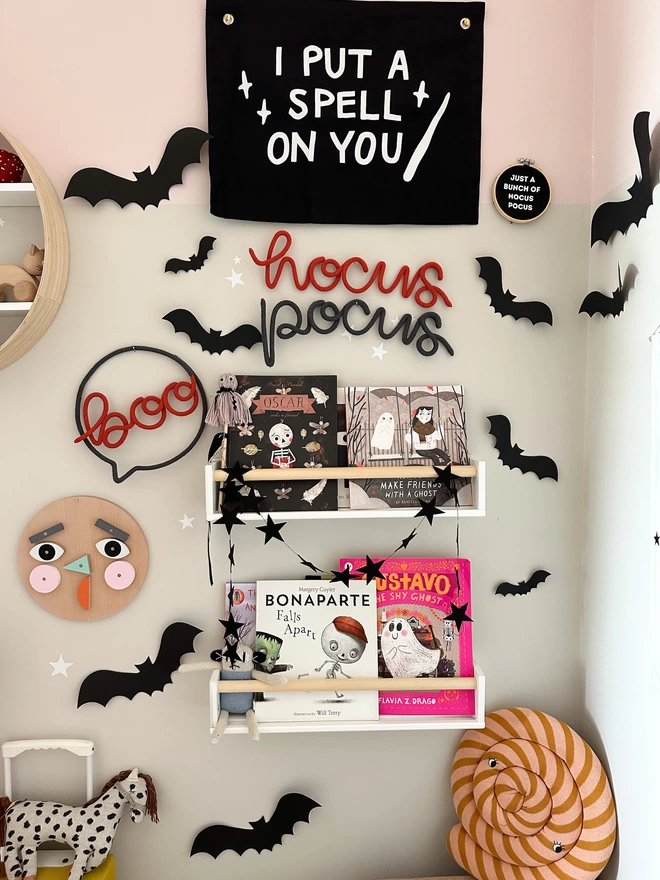 Knitted wire shape 'boo' speech bubble Halloween sign hanging up in the reading area of a child's playroom or bedroom.