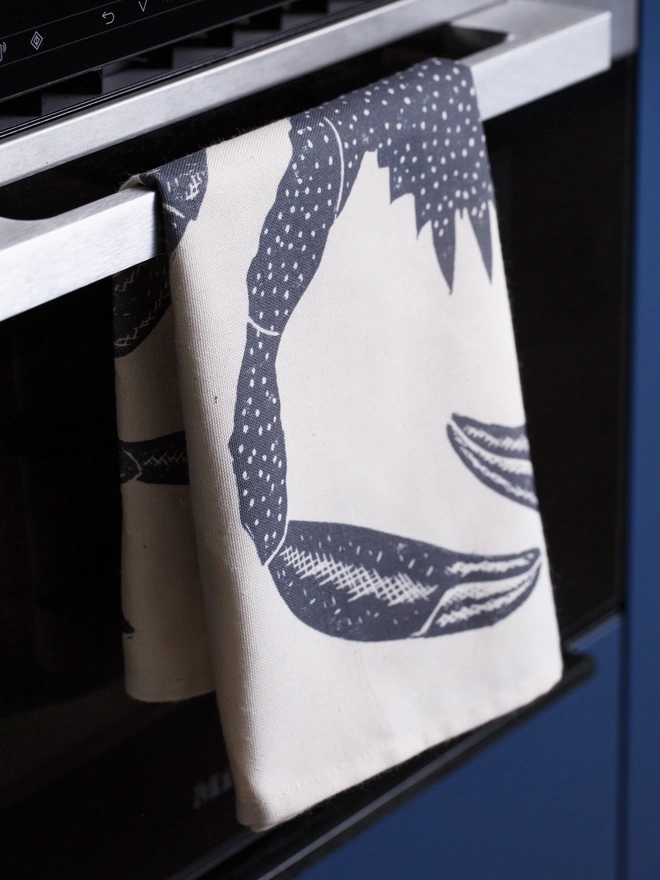 Picture of a tea towel in the kitchen with an image of a spider crab, taken from an original lino print