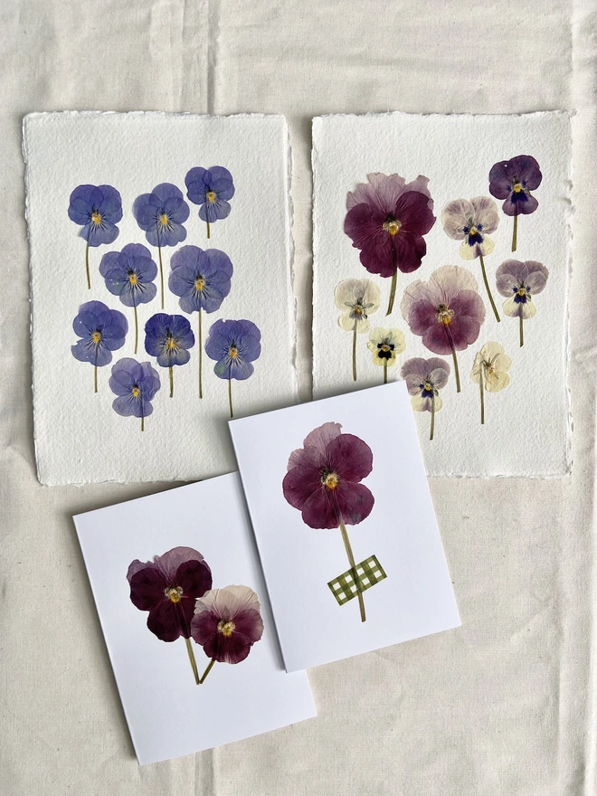 Four different cards and artworks with pressed pansy flowers