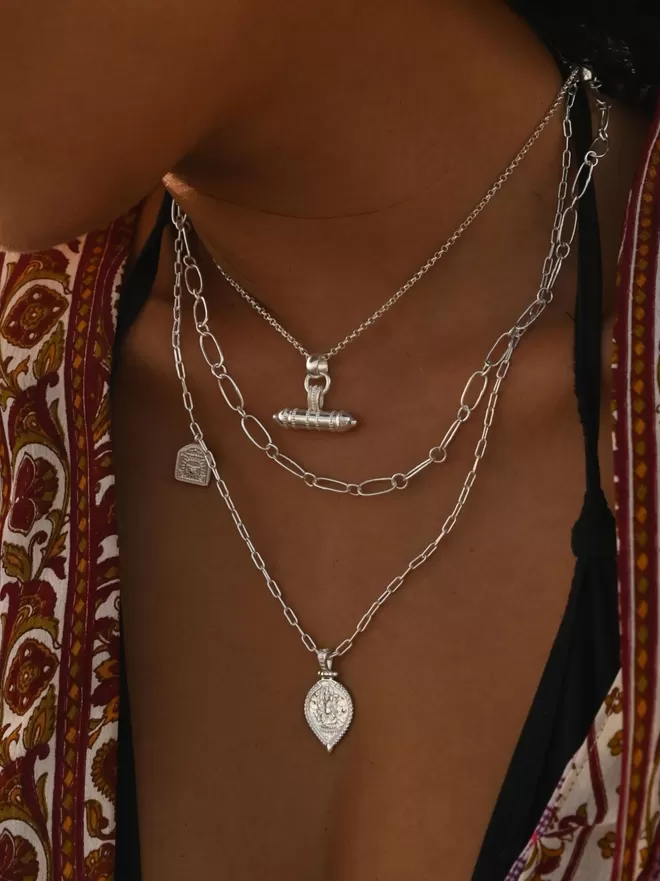 Silver layering necklaces with amulet and Ganesha charms by Loft & Daughter