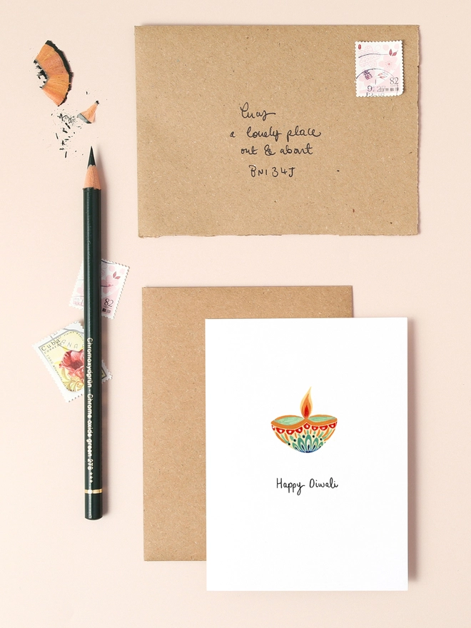 A vibrant illustration featuring a traditional Indian diya (oil lamp) adorned with intricate patterns and warm gold accents, symbolising the Festival of Lights. The card's design combines rich colours and elegant details, making it a perfect choice for sending heartfelt Diwali greetings.