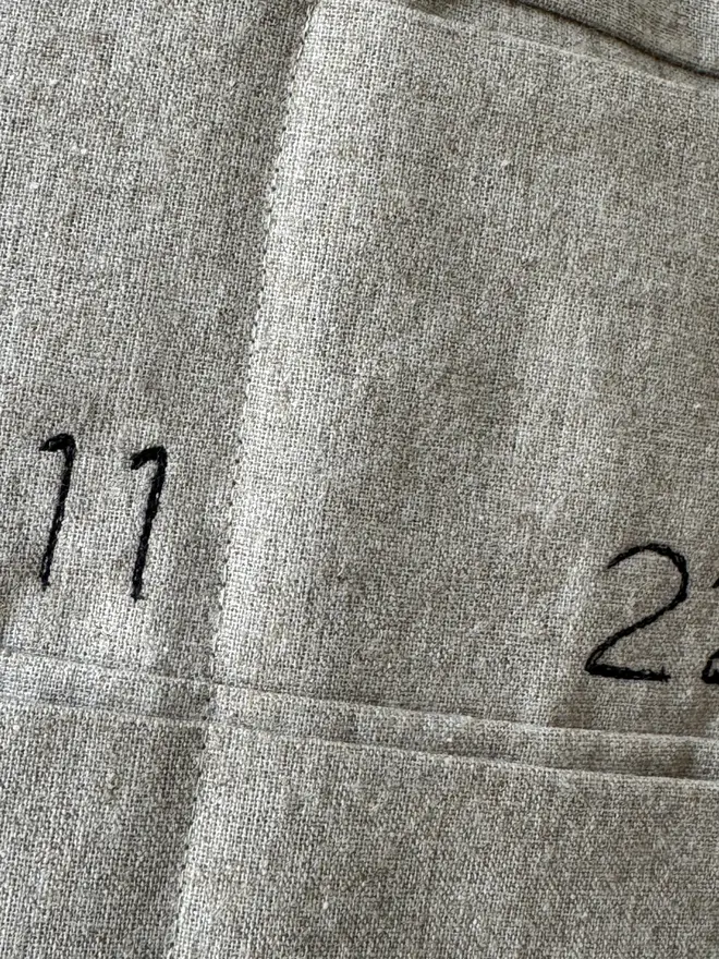Linen Embroidered Advent Calendar. Close up of fabric and stitched numbers