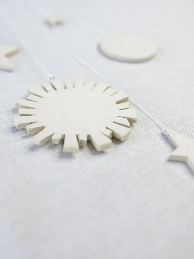 Raw clay underside of ceramic sun, moon and stars hanging decoration