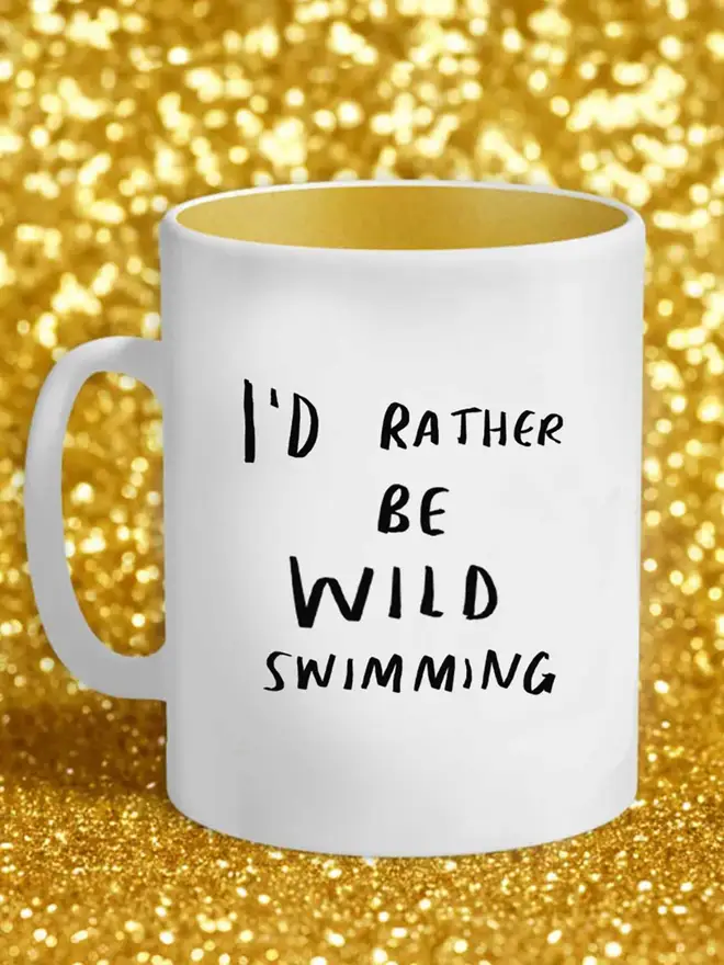 White mug displays the text 'I'd rather be wild swimming'