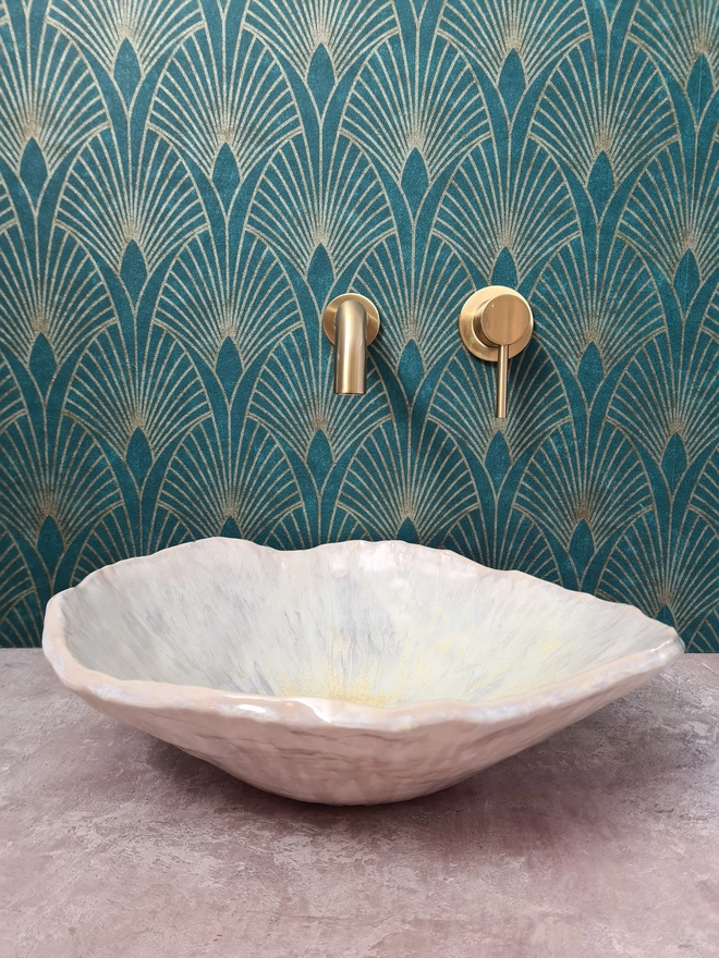 Ceramic bathroom basin, hand-crafted basin, sink, wc, bathroom, ensuite, modern bathroom, photographed against colourful green art deco wallpaper with gold taps, front view