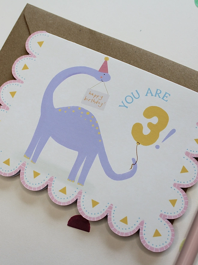 illustrated dinosaur birthday card. scallop edged card illustrated with stegosaurus.