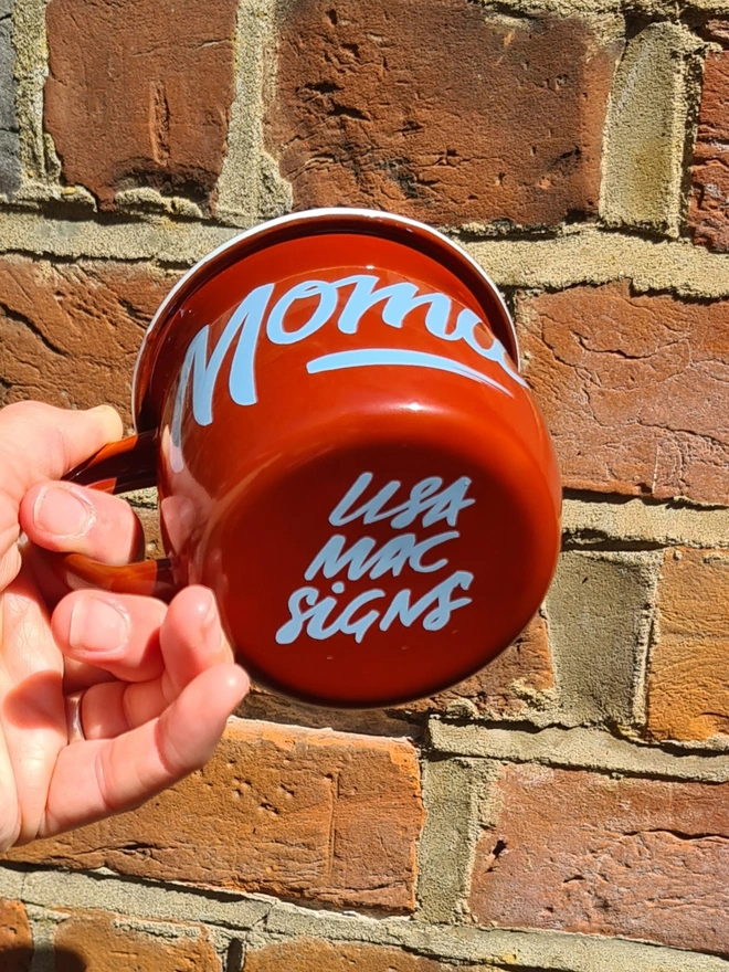 Red mug with light blue script on side and bottom