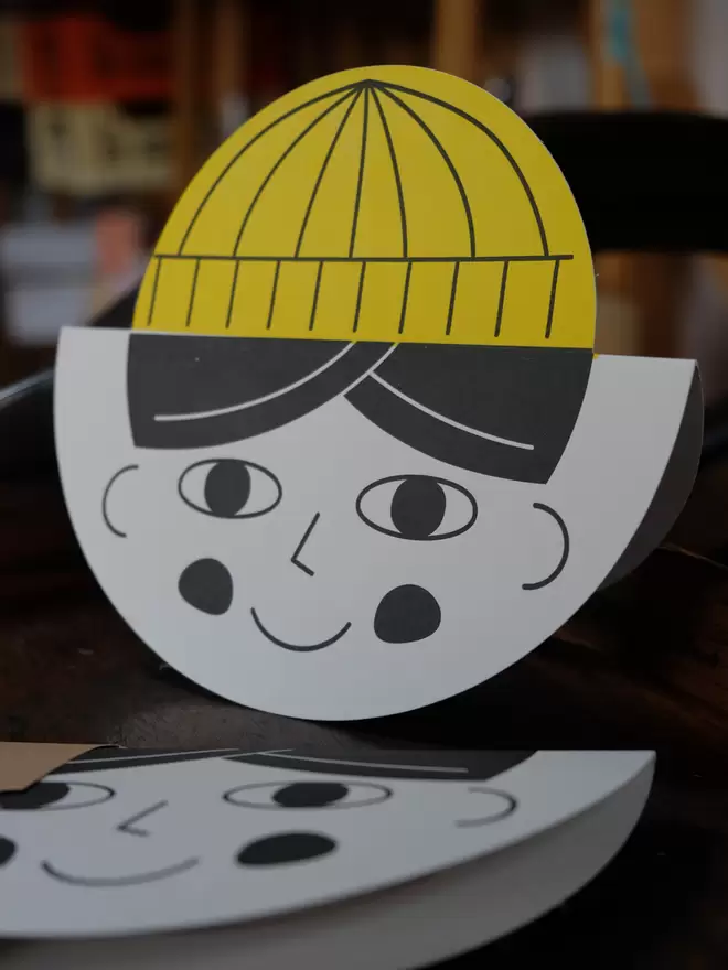Fun, illustrative childs face card with yellow hat.