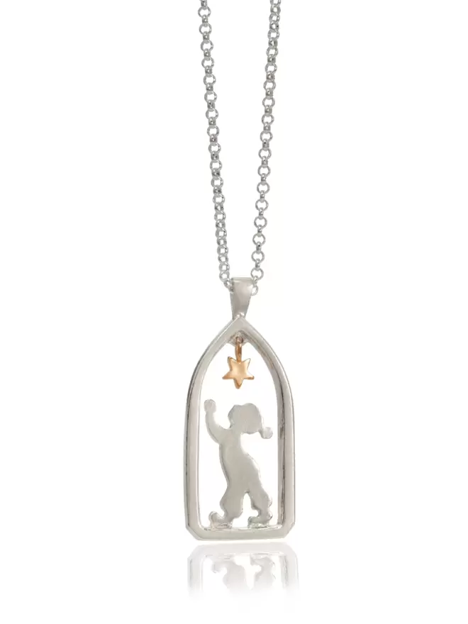 silver pendant on silver chain pendant shows boy child figure reaching up in profile to a suspended golden star