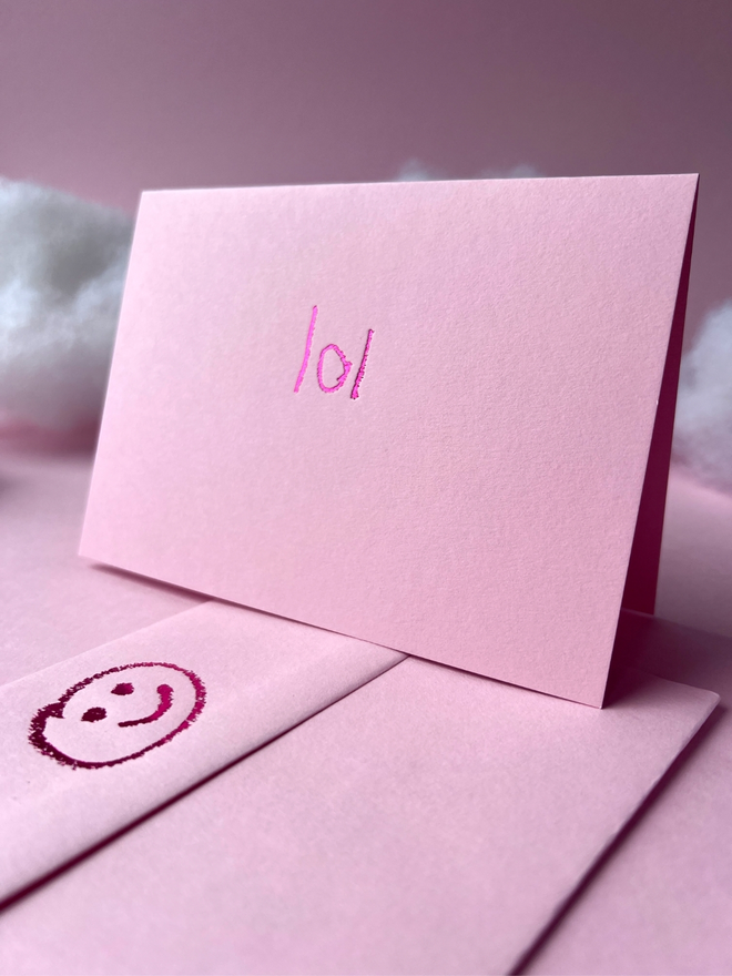 pastel pink coloured card with lol short for 'laugh out loud' or 'lots of love' hand foiled in kids hand writing
