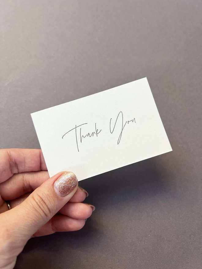 Letterpress printed tiny note illustrated with a thank you in modern calligraphy