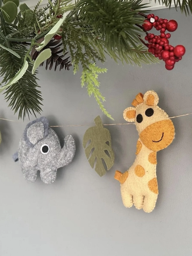 Nursery Safari Garland, a safari themed garland hanging in a child's bedroom against a grey backdrop. 