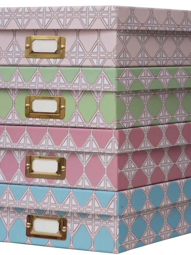 Tijan Lidded Portfolio Box, a collection of colourful portfolio boxes stacked on a plain surface. 