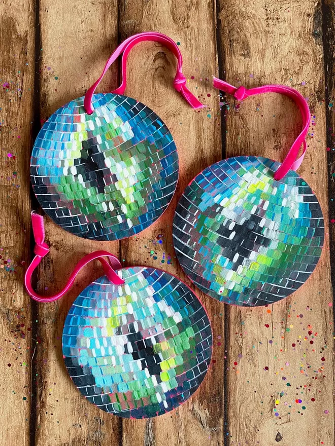 a group of round ornaments with pink string