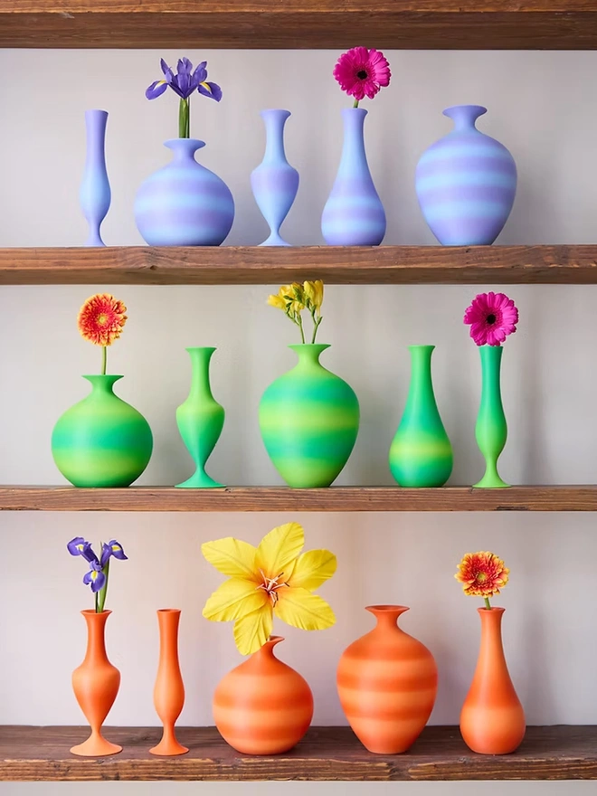 shelf of bright coloured 3d printed vases
